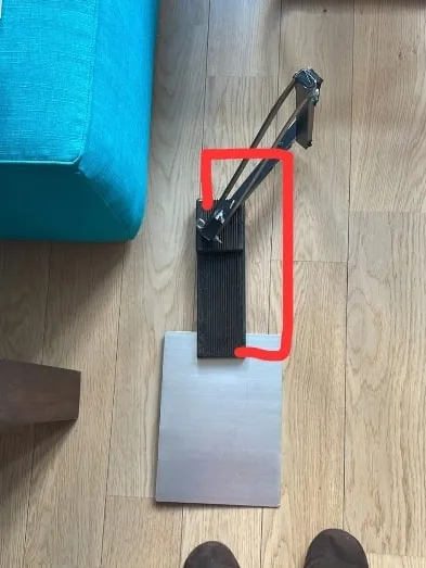 The first homemade prototype on a wooden floor, outlined in red